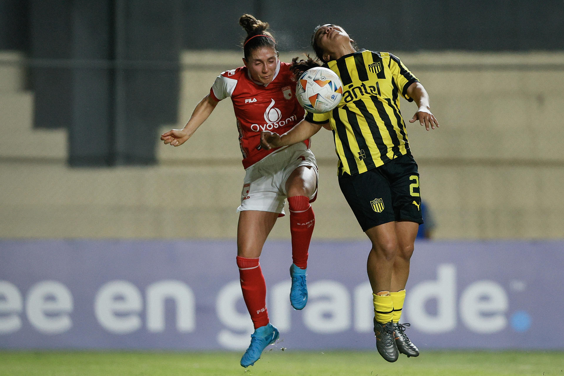 La jugadora de Peñarol Sasha Larrea Tregartten (d) disputa este viernes el balón con  la centrocampista de Santa Fe Natalia Gaián en el debut sin goles de ambos equipos en la Copa Libertadores, cuyo partido se jugó en el estadio asunceno Arsenio Erico.  EFE/ Juan Pablo Pino
