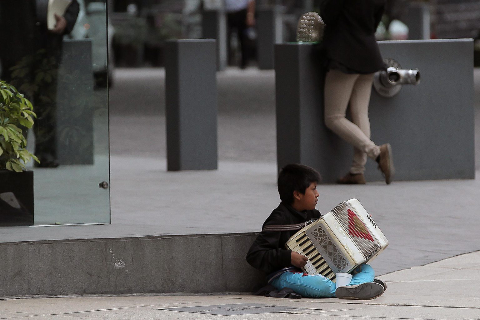 Fotografía de archivo fechada el 13 de agosto de 2015 que muestra a un niño mientras toca el acordeón para ganar un sustento, en una calle de la Ciudad de México (México). Archivo. EFE/Alex Cruz