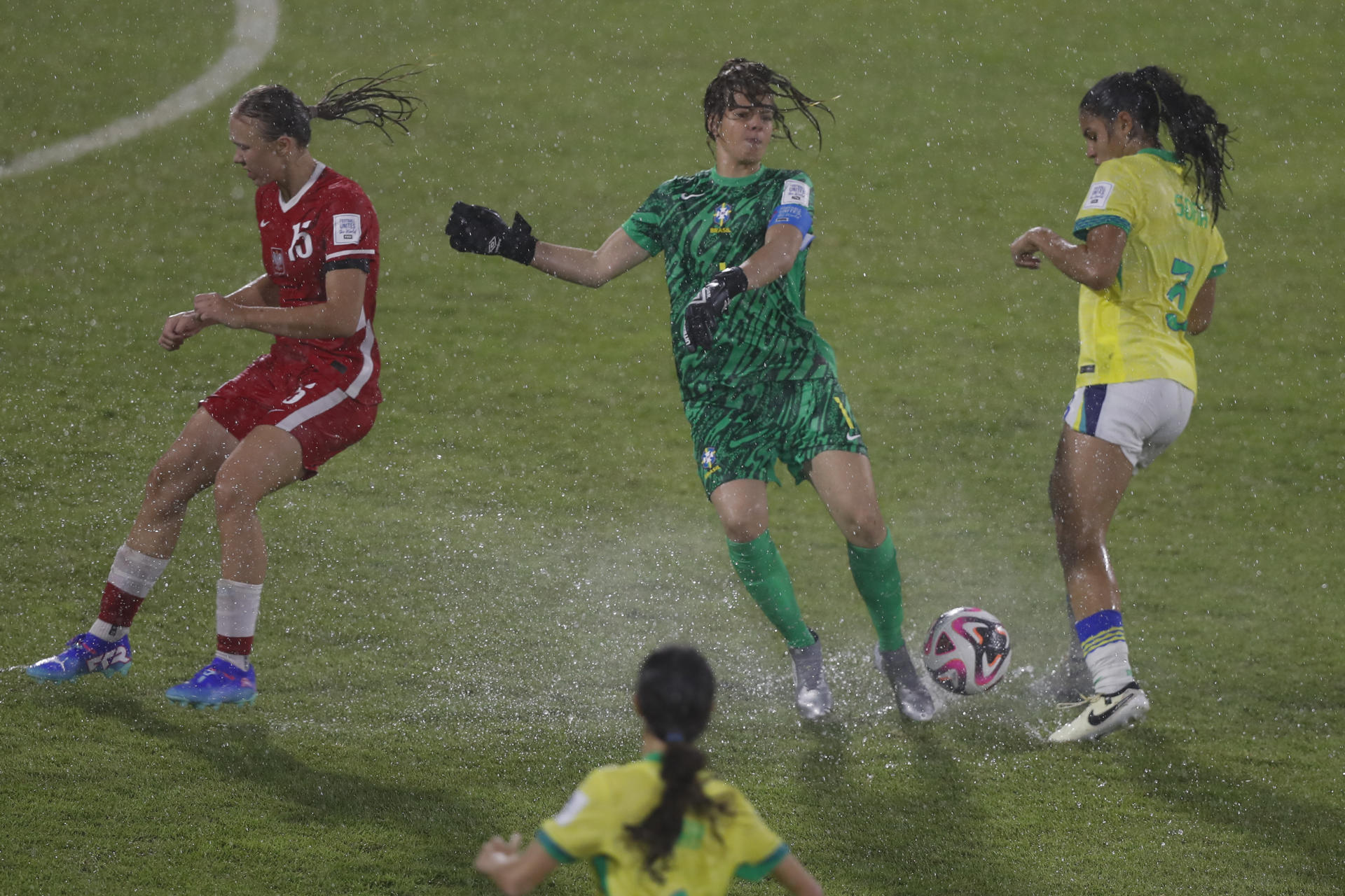 Weronika Araśniewicz (i), de Polonia, en una acción del partido con la portera de Brasil Ana Morganti (c), que fue expulsada al final del juego. EFE/ Diana Sánchez
