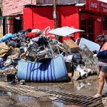 Una persona camina entre basura y enseres domésticos abandonados este lunes en las calles de la unidad habitacional Colosio, una de las más afectadas tras el paso del huracán John, en el balneario de Acapulco (México). EFE/David Guzmán