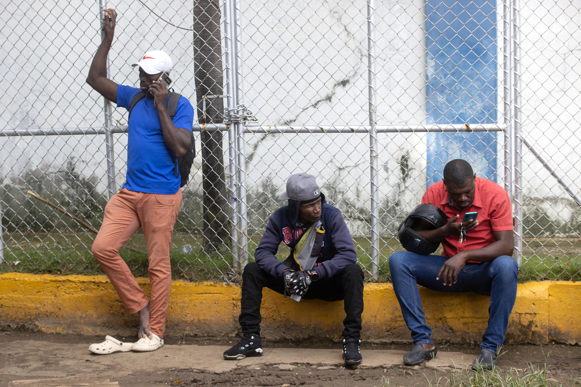 Haitianos llegan a preguntar por familiares detenidos en el centro de recepción de migrantes este lunes en Haina (República Dominicana). EFE/Orlando Barría
