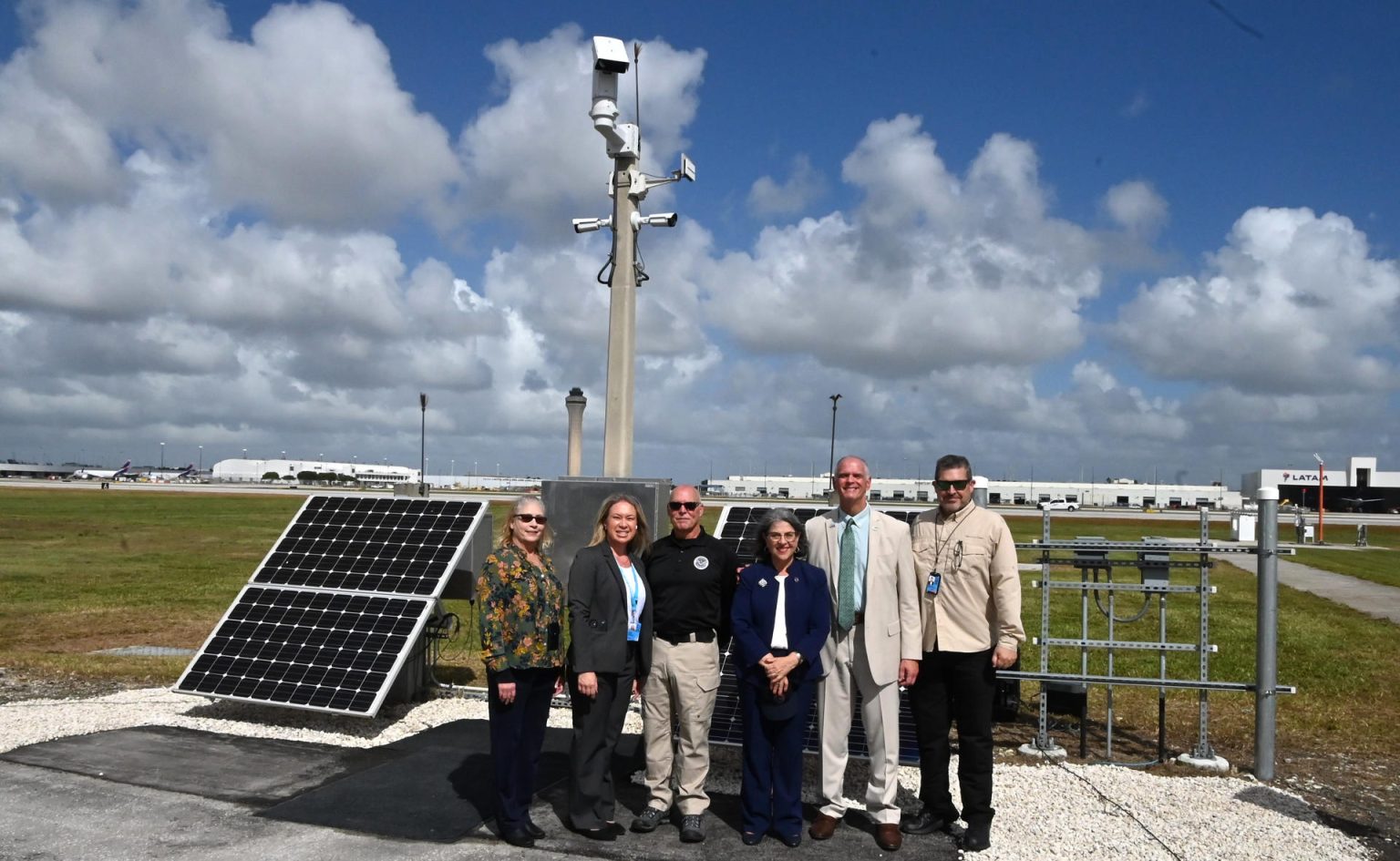 Fotografía cedida por el Aeropuerto Internacional de Miami (MIA) donde aparecen (de izquierda a derecha) la gerente de seguridad del aeropuerto, Susan Feeney; la gerente de construcción, Leslie Livesay; el director de Capacidades Multimodales y de Área Pública (MPAC) de la Administración de Seguridad del Transporte (TSA), Jim Bamberger; la alcaldesa del condado Miami-Dade, Daniella Levine Cava; el director y presidente ejecutivo del aeropuerto, Ralph Cutié, y el director adjunto de seguridad pública y protección, Mark Hatfield, mientras posan cerca de una cámara con Sistema de Detección de Intrusiones Perimetrales (PIDS) en el aeropuerto en Miami, Florida (EE. UU). EFE/MIA /SOLO USO EDITORIAL /NO VENTAS /SOLO DISPONIBLE PARA ILUSTRAR LA NOTICIA QUE ACOMPAÑA /CRÉDITO OBLIGATORIO