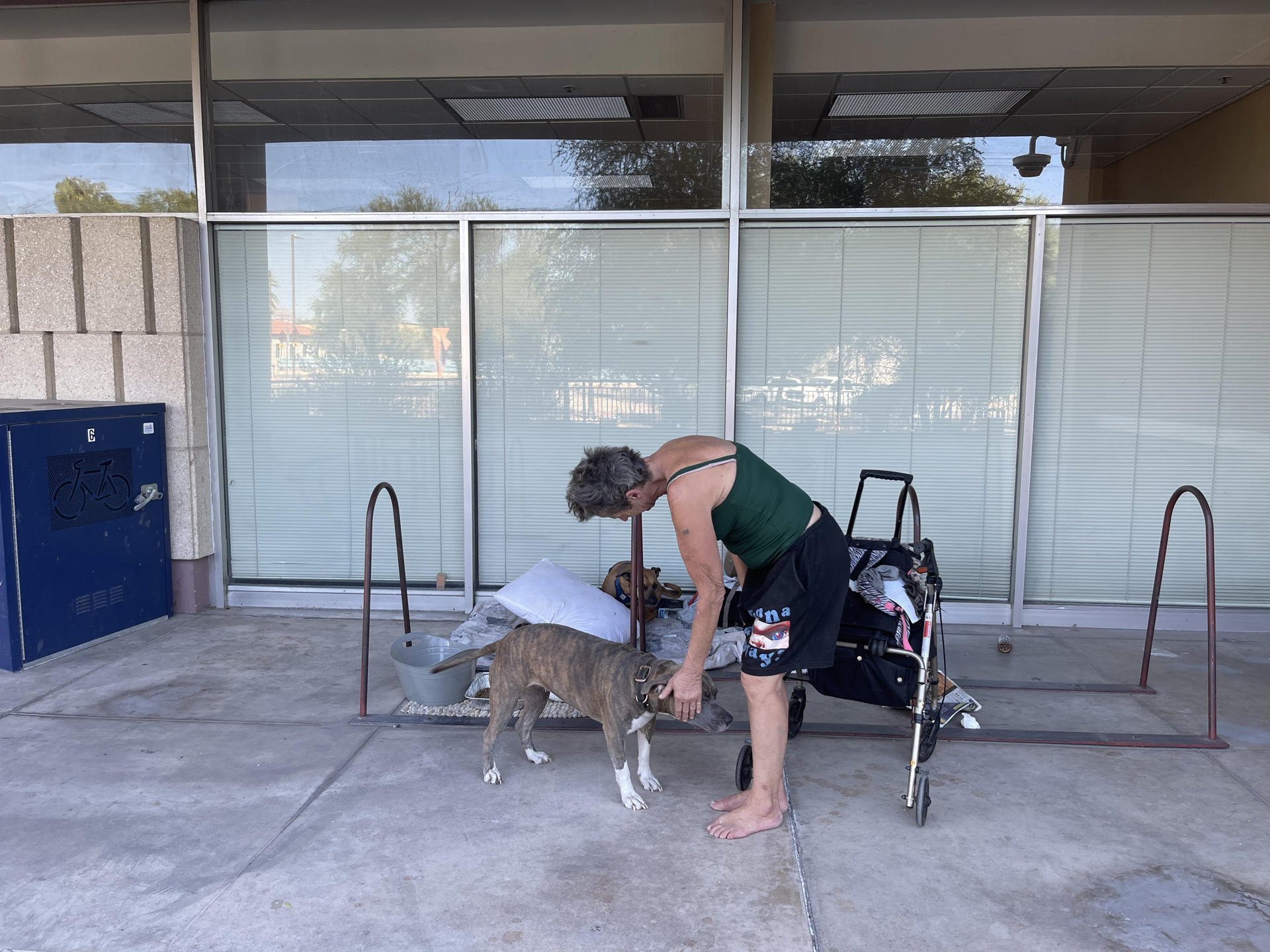 Fotografía del 29 de septiembre de 2024 de una persona sin hogar acariciando a su perro en el pasillo de entrada del Ayuntamiento de Tucson en Arizona (Estados Unidos). EFE/ Ana Milena Varón
