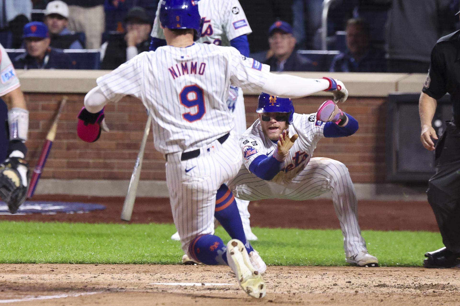 Nueva York (Estados Unidos), 10/08/2024.- Harrison Bader (D) de los Mets reacciona ante el deslizamiento de Brandon Nimmo (9) hacia el plato durante la séptima entrada del tercer juego de los playoffs de la Serie Divisional de la Liga Nacional de las Grandes Ligas de Béisbol (MLB) entre los Filis de Filadelfia y los Mets de Nueva York.EFE/EPA/SARAH YENESEL
