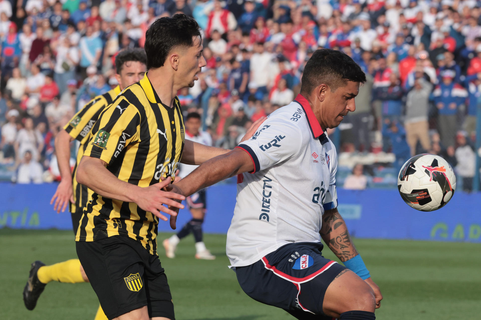 Diego Polenta (d) de Nacional disputa un balón con Maximiliano Silvera de Peñarol en un partido de la fecha 6 del Torneo Clausura de la Primera División de Uruguay. EFE/ Gaston Britos
