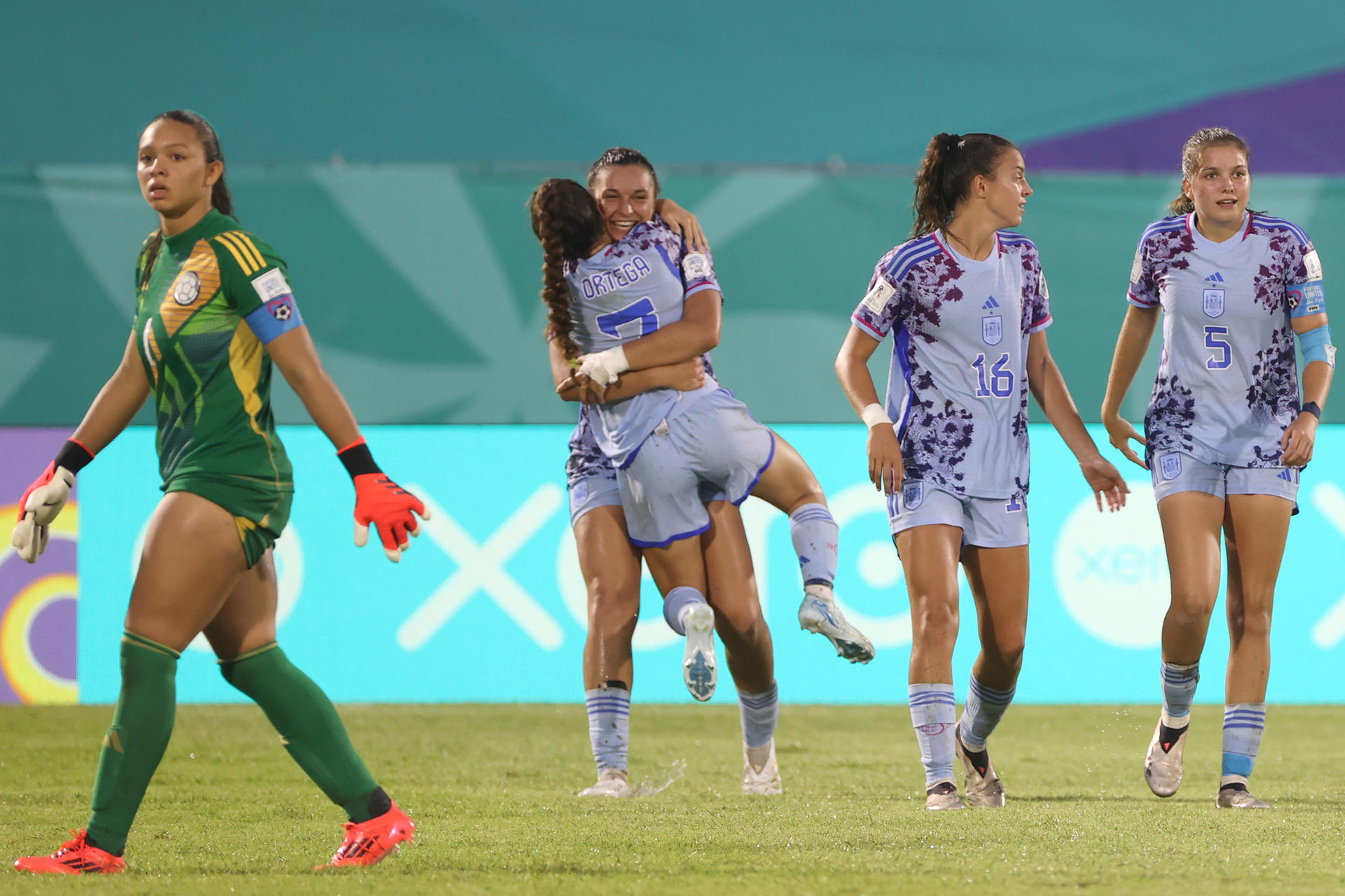 Jugadoras de la selección sub-17 de España celebran este martes en Santo Domingo la victoria por 1-2 sobre la de Colombia en el cierre de la fase de grupos del Mundial ante la decepción de la portera colombiana Luisa Agudelo. EFE/ Orlando Barría
