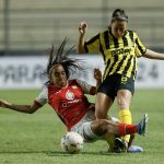 La jugadora de Peñarol Stephanie Tregartten (d) disputa este viernes el balón con  la defensora Mariana Zamorano de Santa Fe en el debut sin goles de ambos equipos en la Copa Libertadores cuyo partido se jugó en el estadio asunceno Arsenio Erico.  EFE/ Juan Pablo Pino