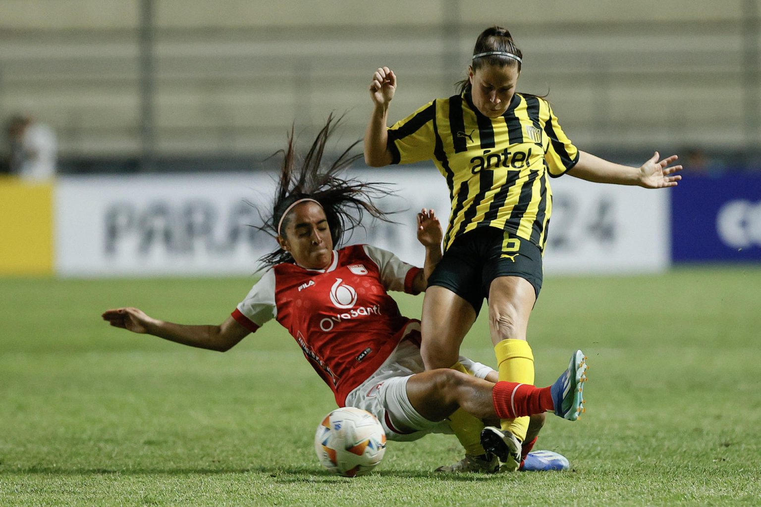 La jugadora de Peñarol Stephanie Tregartten (d) disputa este viernes el balón con  la defensora Mariana Zamorano de Santa Fe en el debut sin goles de ambos equipos en la Copa Libertadores cuyo partido se jugó en el estadio asunceno Arsenio Erico.  EFE/ Juan Pablo Pino