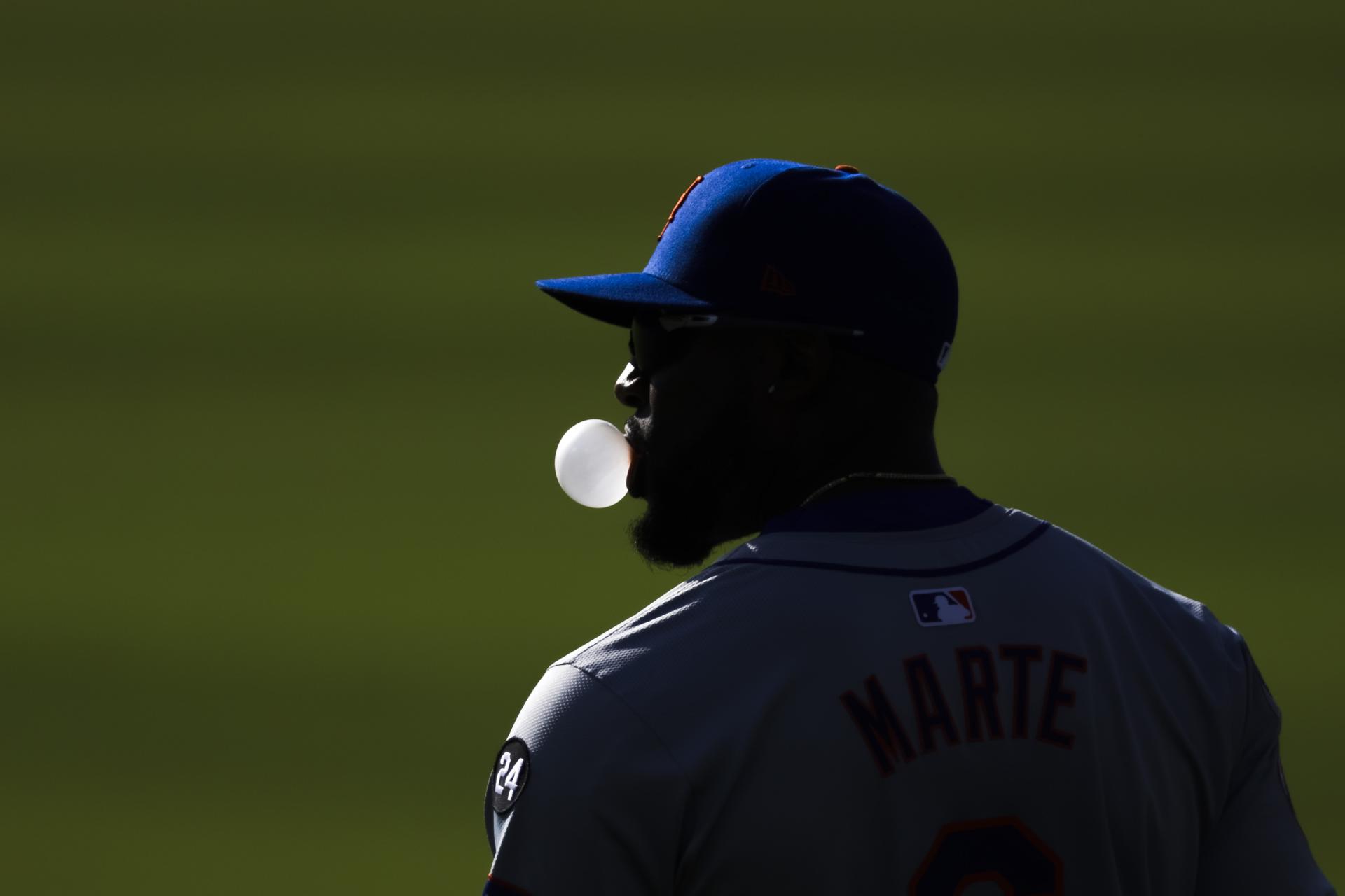 Starling Marte de los Mets sopla una burbuja de chicle este lunes durante el segundo juego de la Serie de la Liga Nacional de las Grandes Ligas.EFE/EPA/ALLISON
