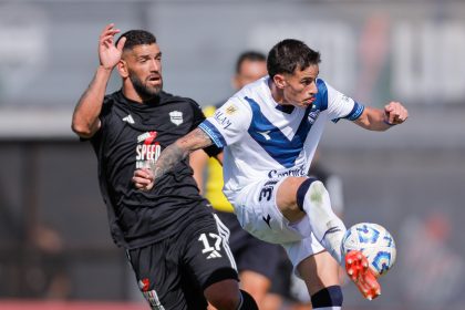 Gustavo Fernández (i), del Deportivo de Riestra, disputa el balón con Valentín Gómez, de Vélez, en juego de la Primera División de Argentina en el estadio Guillermo Laza en Buenos Aires. EFE/ Juan Ignacio Roncoroni