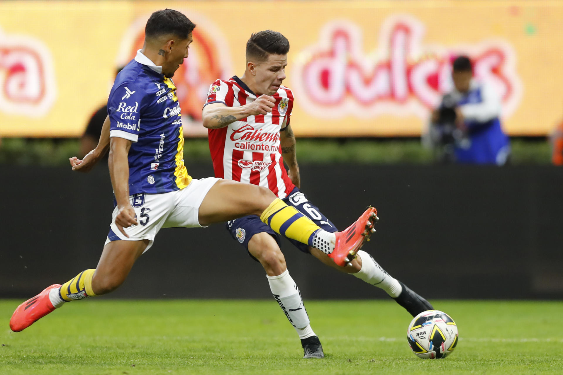 Pavel Pérez (d) de Guadalajara disputa el balón con Ricardo Chávez (i) de San Luis este sábado en el estadio Estadio Akron. EFE/ Francisco Guasco
