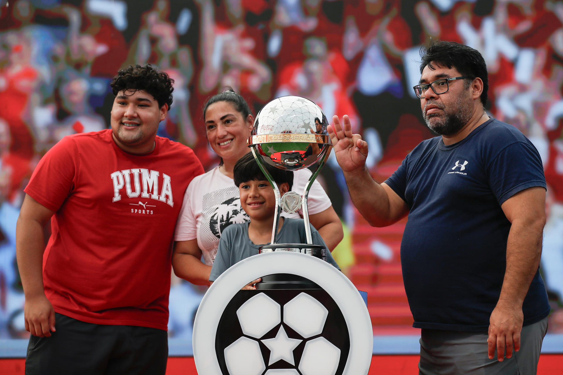 Hinchas del fútbol posan este jueves alrededor de la Copa Sudamericana que recibirá el campéon de la vigésima tercera edición el próximo domingo en Asunción entre Racing y Cruzeiro. EFE/ Juan Pablo Pino
