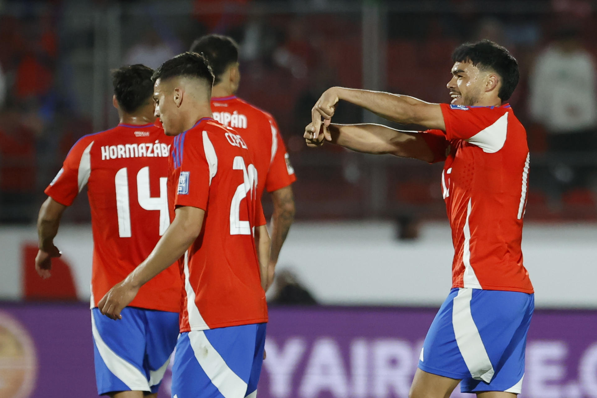 Gabriel Suazo (d), centrocampista de Chile, fue registrado este marte, 19 de noviembre, celebra un gol que le anotó a Venezuela, durante un partido de la fecha 12 de las eliminatorias sudamericanas al Mundial FIFA de 2026, en el estadio Nacional de Santiago de Chile. EFE/Elvis González
