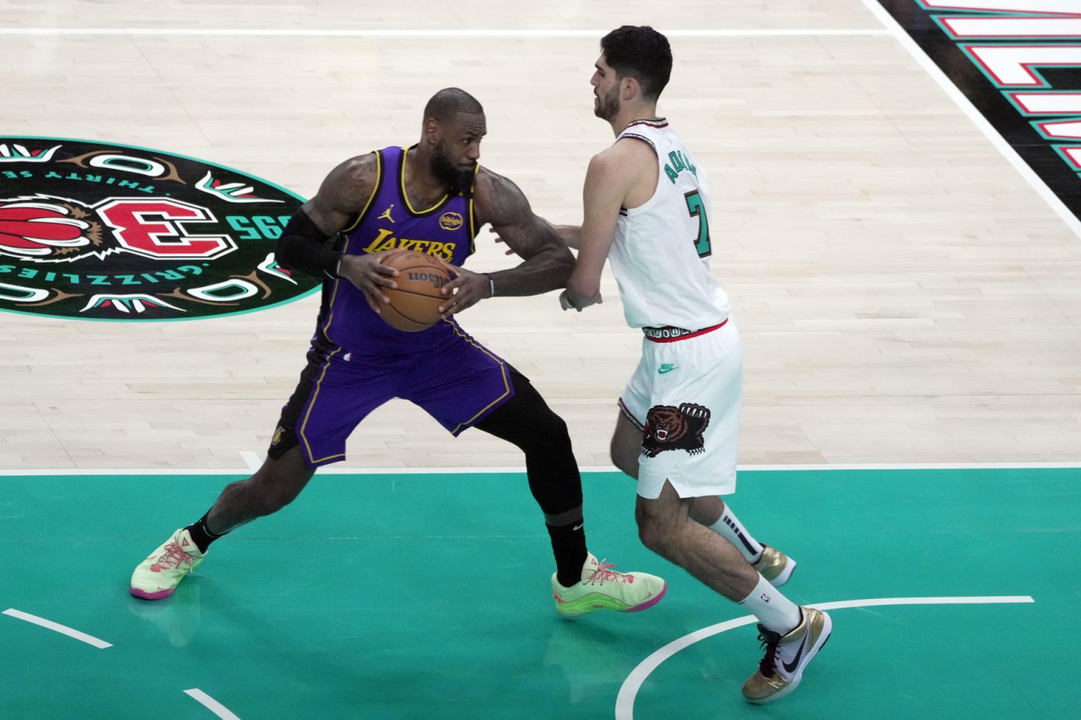 El alero Santi Aldama (d) de Grizzlies defiende la entrada a canasta del alero LeBron James, de Los Lakers, durante el partido entre Memphis Grizzlies y Los Angeles Lakers, en el FedEx Forum en Memphis, Tennesse (Estados Unidos).EFE/ Karen Pulfer Focht