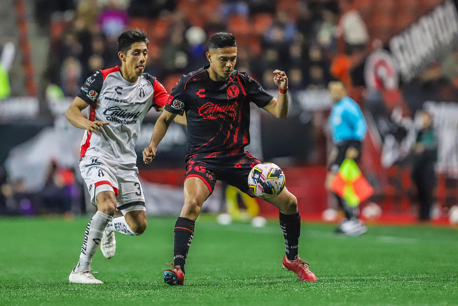 Jesús Vega (d) de Tijuana disputa el balón con Idekel Domínguez (i) de Atlas en el partido jugado este domingo en el estadio Caliente de la ciudad de Tijuana que clasificó al equipo local a los cuartos de final del Torneo Apertura mexicano. EFE/ Alejandro Zepeda
