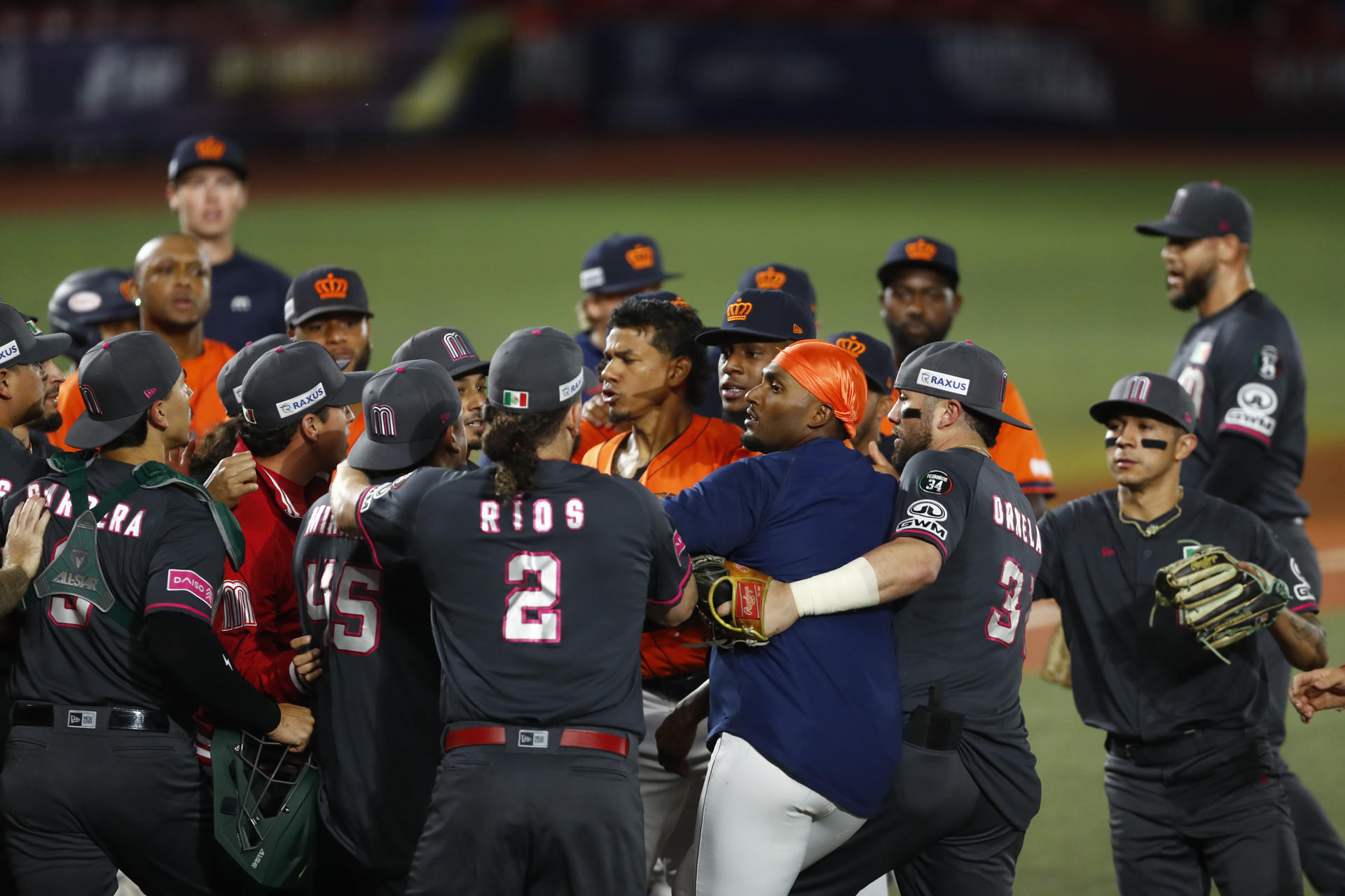 Jugadores mexicanos (i) y neerlandeses (d) discuten tras concluir el partido del Premier 12 de la Confederación Mundial de Béisbol y Sóftbol (WBSC) disputado este miércoles, en el Estadio Panamericano de Béisbol, en Guadalajara, Jalisco (México). EFE/Francisco Guasco
