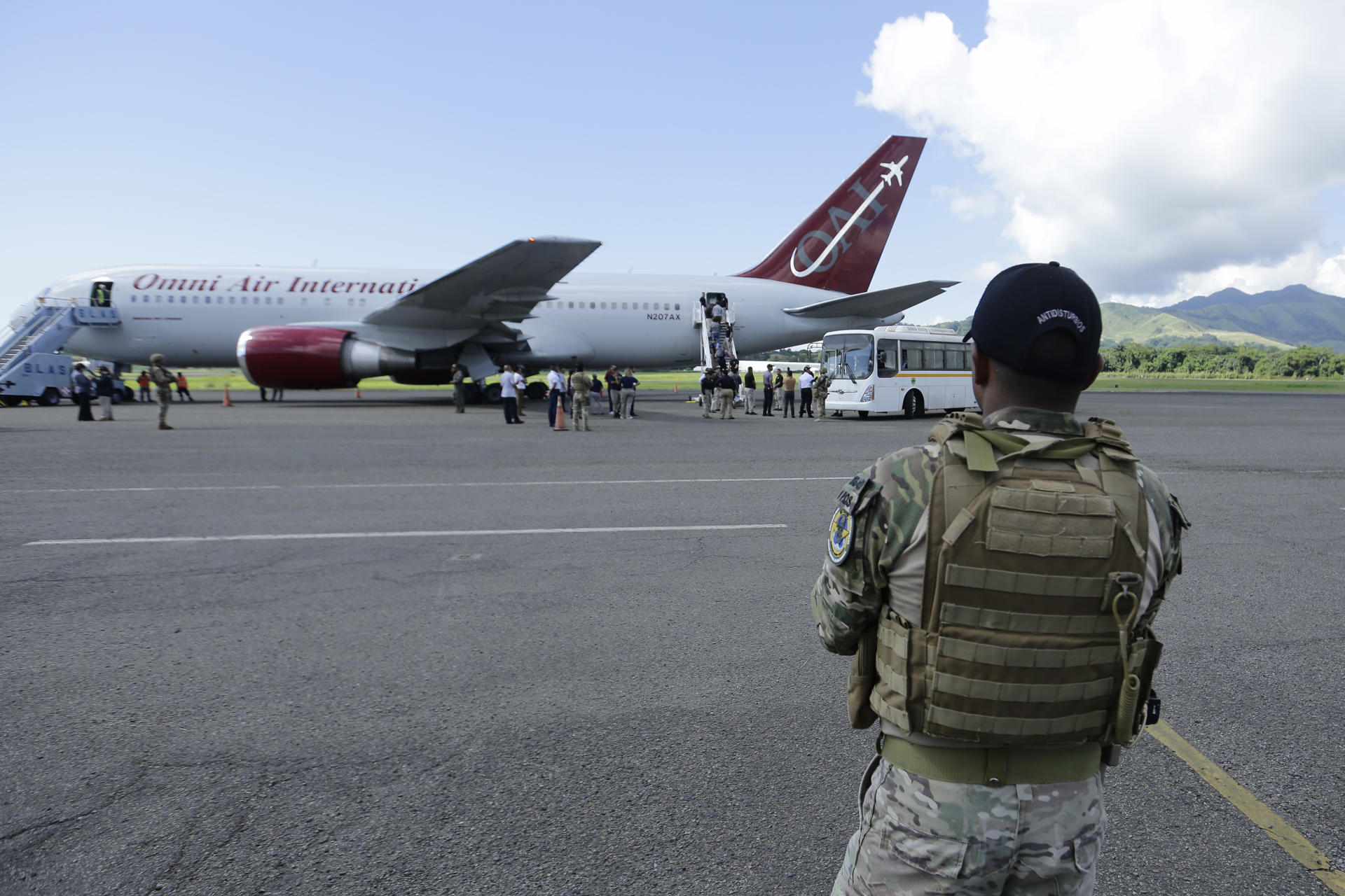 Un soldado observa el ingreso de migrantes de nacionalidad india y vietnamita a un avión para ser deportados, este lunes en Ciudad de Panamá (Panamá). EFE/ Carlos Lemos
