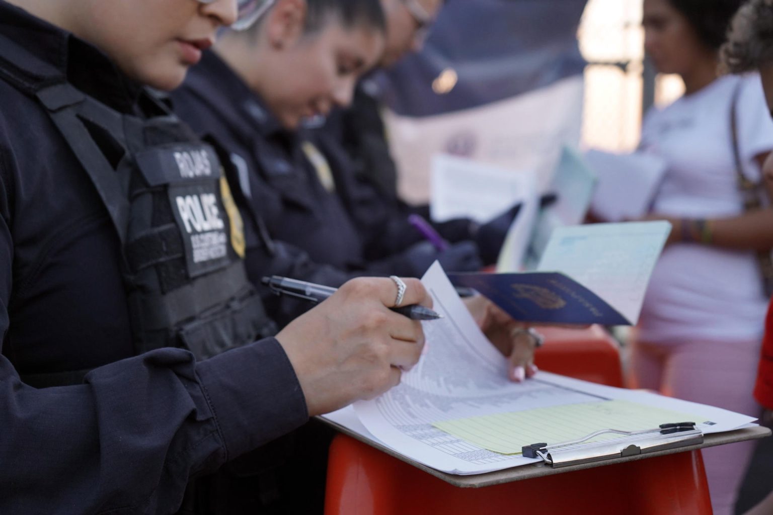 Una agente de la Oficina de Aduanas y Protección Fronteriza de Estados Unidos (CBP) apunta los nombres de inmigrantes que van a entregar su aplicación de entrada a Estados Unidos en la frontera de El Paso,Texas (Estados Unidos). Archivo. EFE/César Contreras