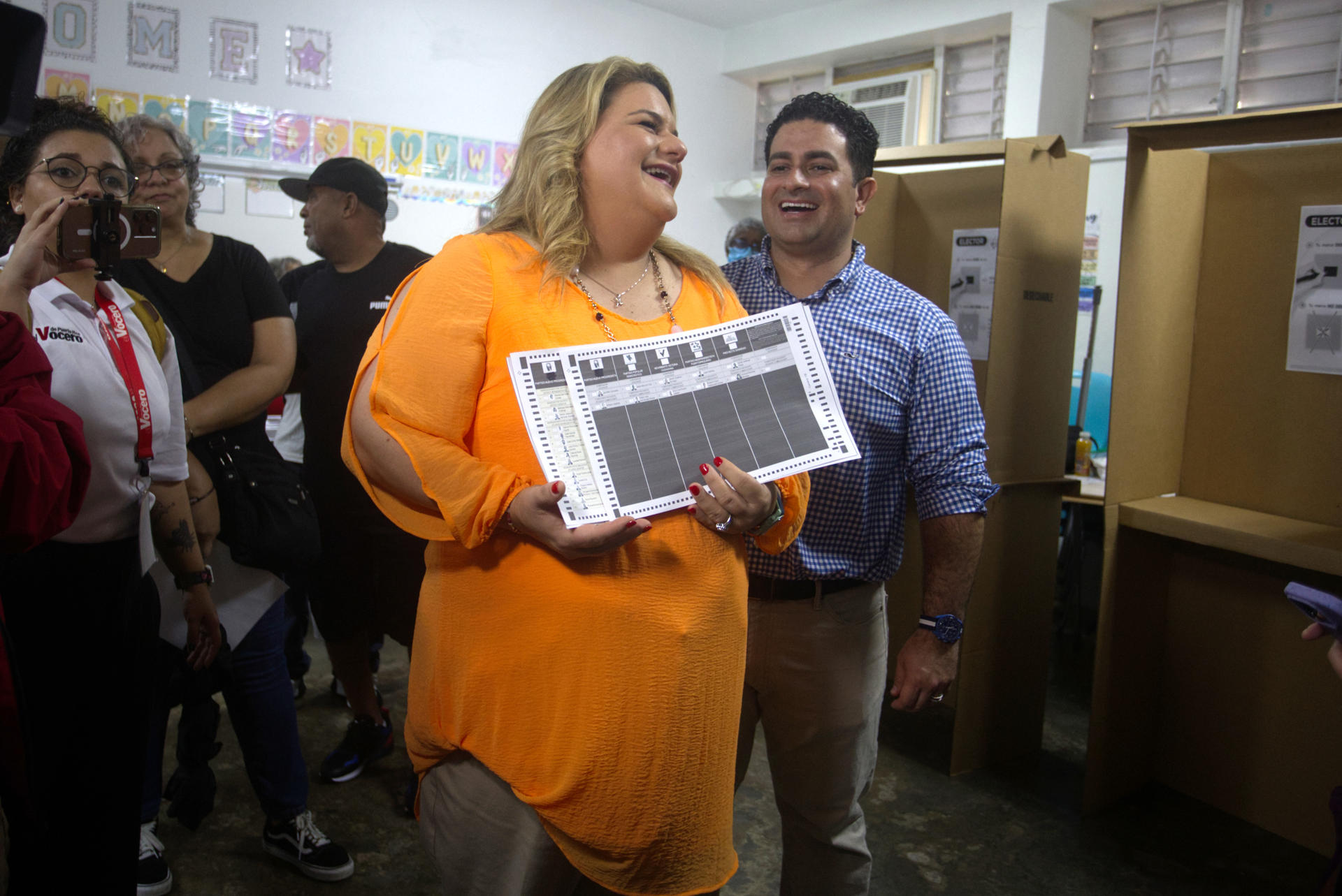 La candidata a la Gobernación de Puerto Rico por el Partido Nuevo Progresista (PNP), Jenniffer González, y su esposo José Jovin Vargas, caminan con unas papeletas de votación en el centro de votación instalado en la escuela Salvador Brau , este martes, en Carolina (Puerto Rico). EFE/ Thais Llora
