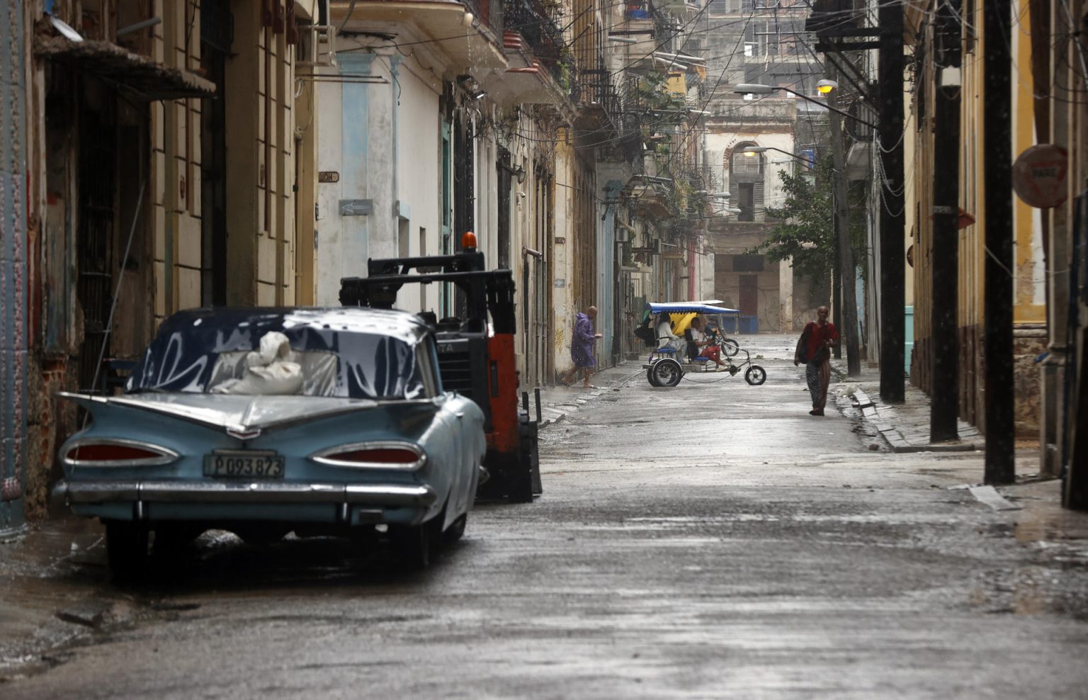 Personas caminan por una calle durante las fuertes lluvias debido al paso del huracán Rafael, ayer miércoles, en La Habana (Cuba). EFE/ Ernesto Mastrascusa