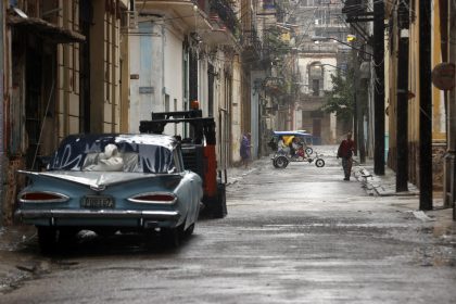 Personas caminan por una calle durante las fuertes lluvias debido al paso del huracán Rafael, ayer miércoles, en La Habana (Cuba). EFE/ Ernesto Mastrascusa