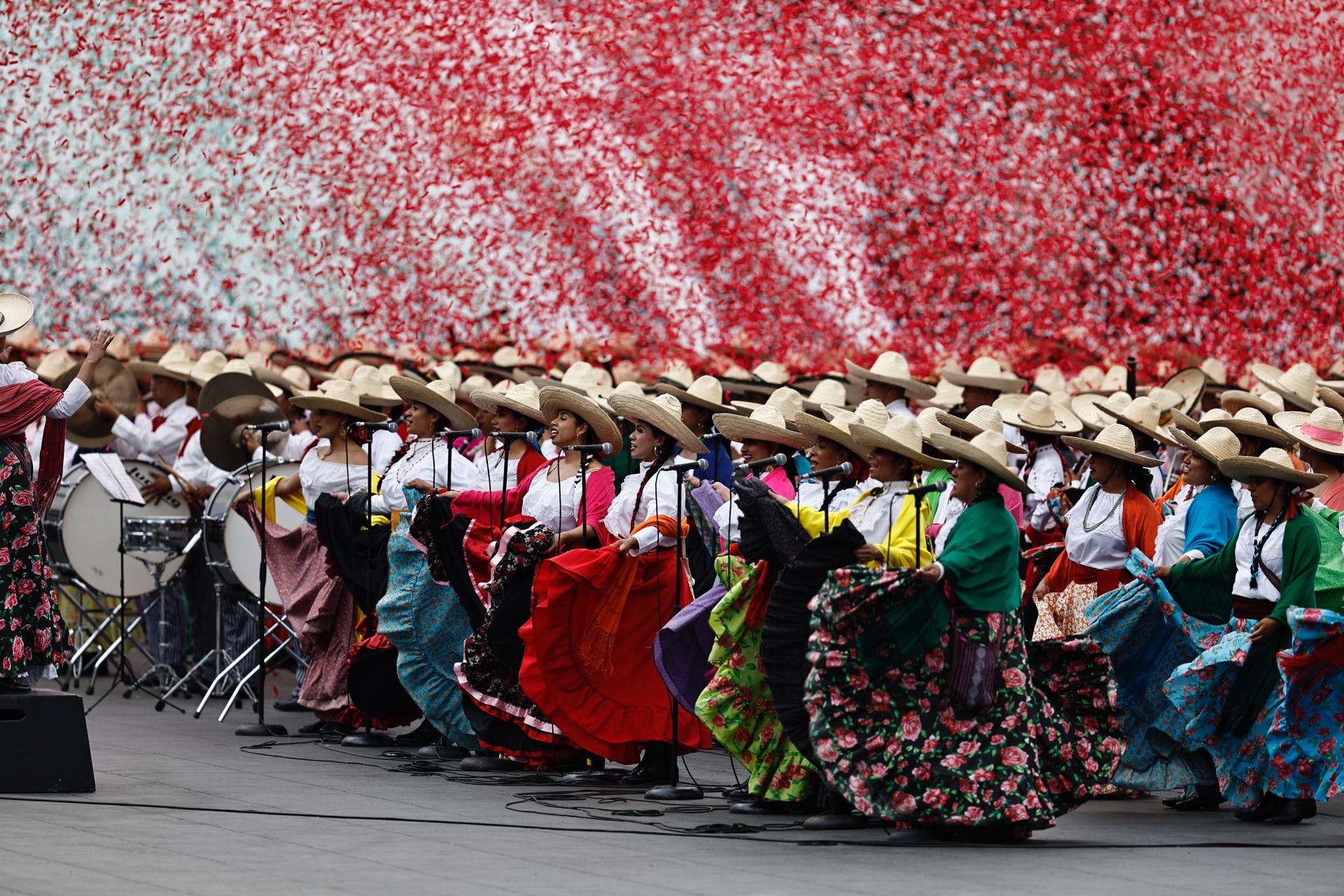 Mujeres con trajes típicos desfilan durante el 114 Aniversario del inicio de la Revolución Mexicana, este miércoles en la Plaza de la Constitución, en Ciudad de México (México). EFE/ Sáshenka Gutiérrez
