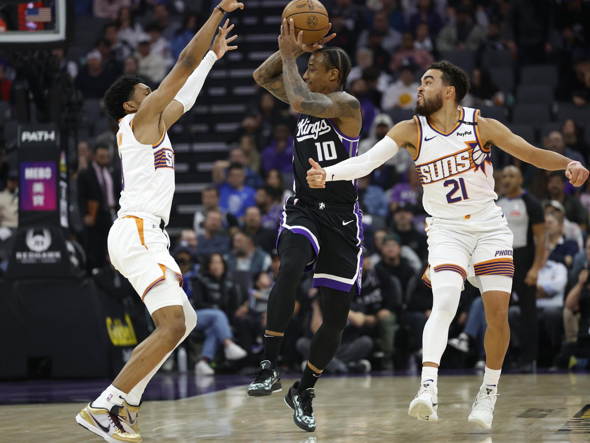 El alero de los Sacramento Kings DeMar DeRozan (C) trata de pasar el balón obstaculizado por Tyus Jones (D) y Ryan Dunn (I), de Phoenix Suns. EFE/EPA/JOHN G. MABANGLO SHUTTERSTOCK FUERA
