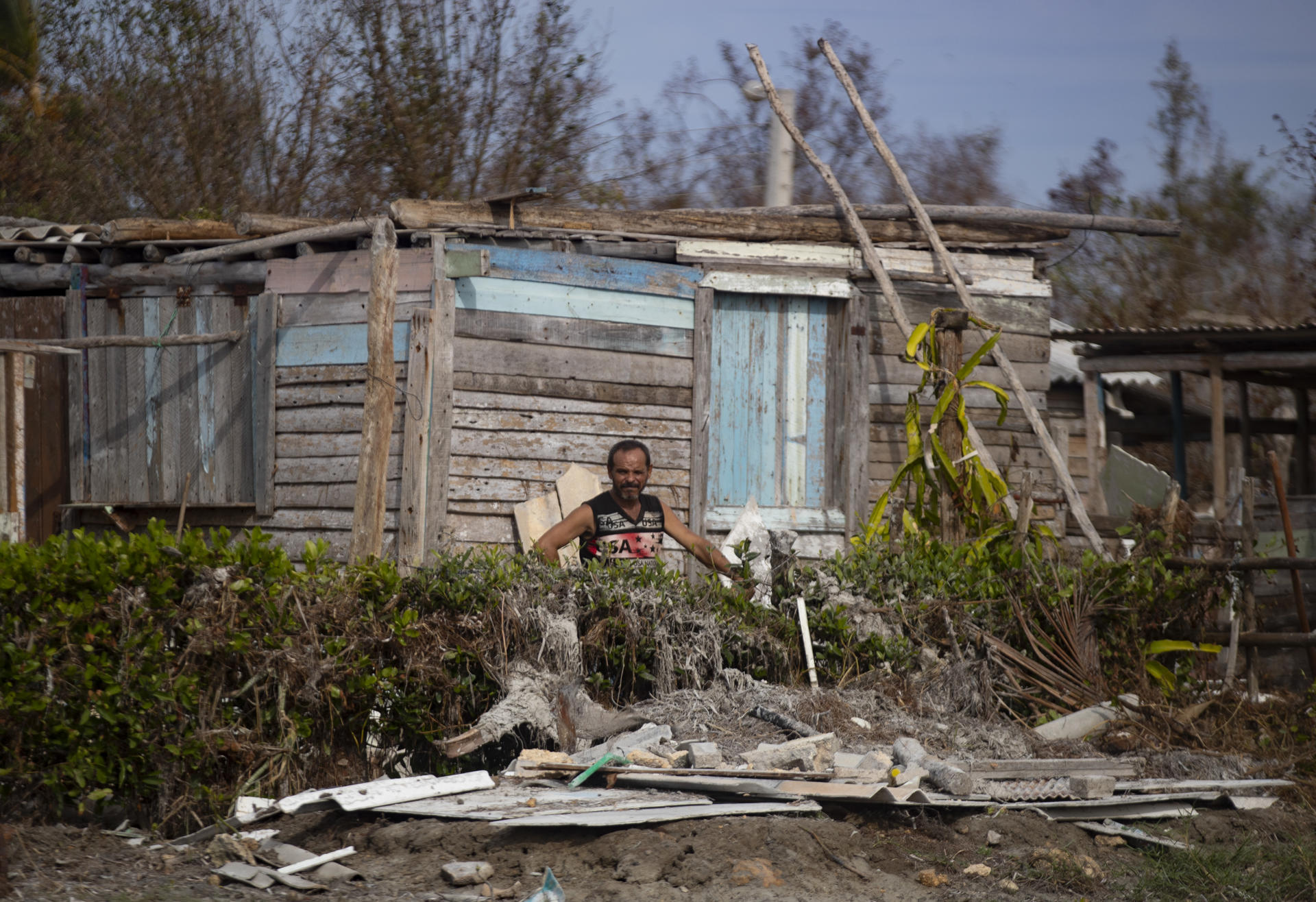 Un hombre espera entre los escombros junto a su casa afectada por el huracán Rafael, este miércoles en Playa Guanimar, Artemisa (Cuba). EFE/Yander Zamora
