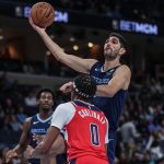 Santi Aldama de Memphis Grizzlies (d) lanza un balón a la canasta frente a Bilal Coulibaly de Washington este viernes, durante un partido entre Memphis Grizzlies y Washington Wizards en el FedExForum, en Memphis (Estados Unidos). EFE/ Patrick Lantrip