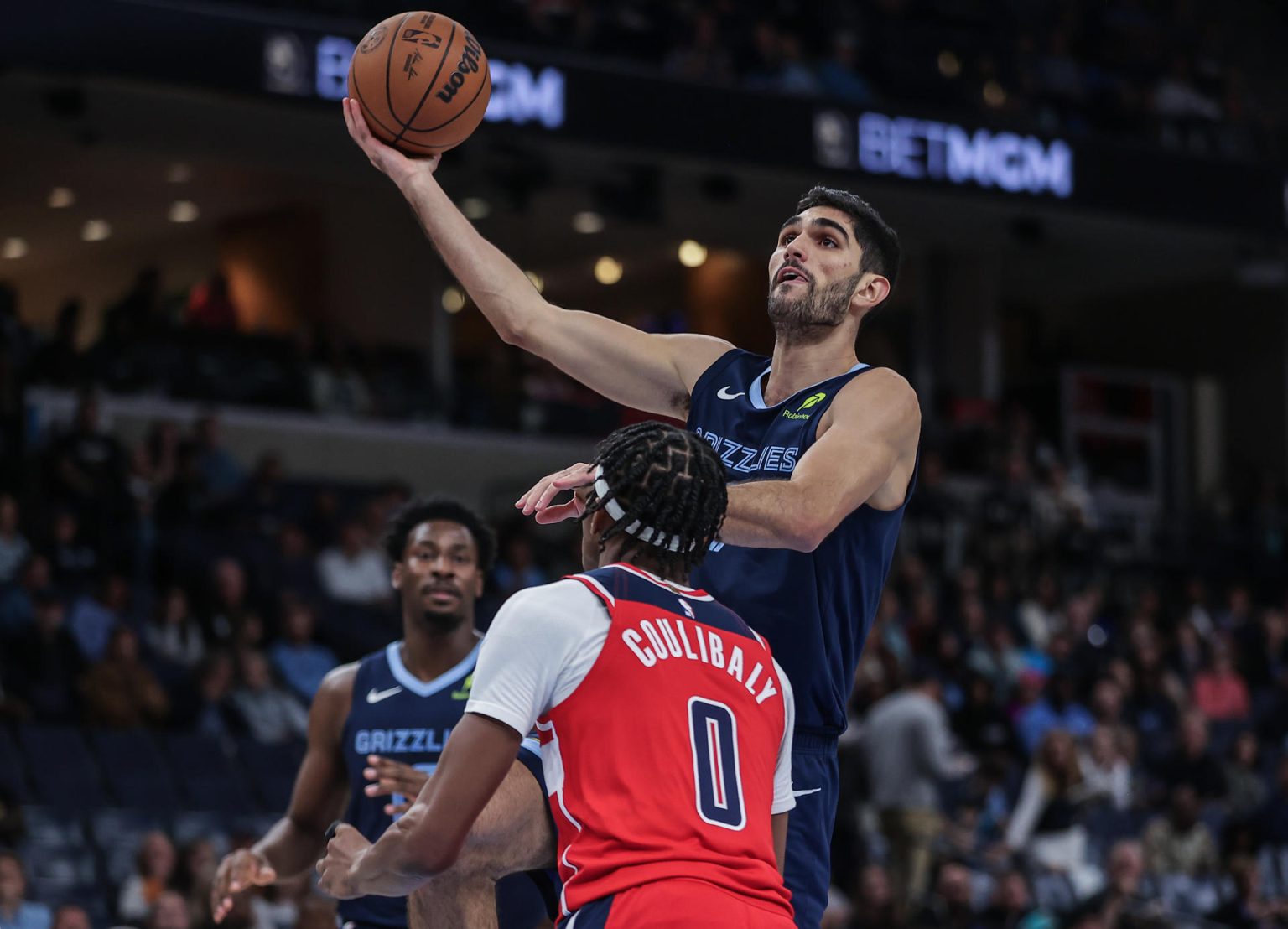 Santi Aldama de Memphis Grizzlies (d) lanza un balón a la canasta frente a Bilal Coulibaly de Washington este viernes, durante un partido entre Memphis Grizzlies y Washington Wizards en el FedExForum, en Memphis (Estados Unidos). EFE/ Patrick Lantrip