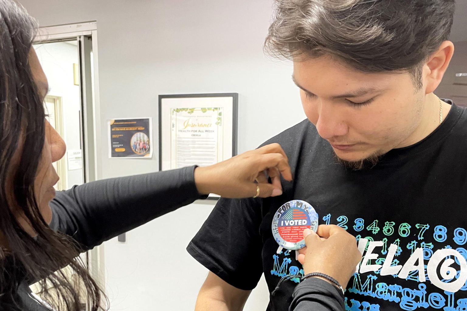 Fotografía del 2 de octubre de 2024 de Carolina Morán colocando a su hijo Angel Gallegos, un botón conmemorativo de 'He votado' en Los Ángeles, California (Estados Unidos). EFE/ Ana Milena Varón