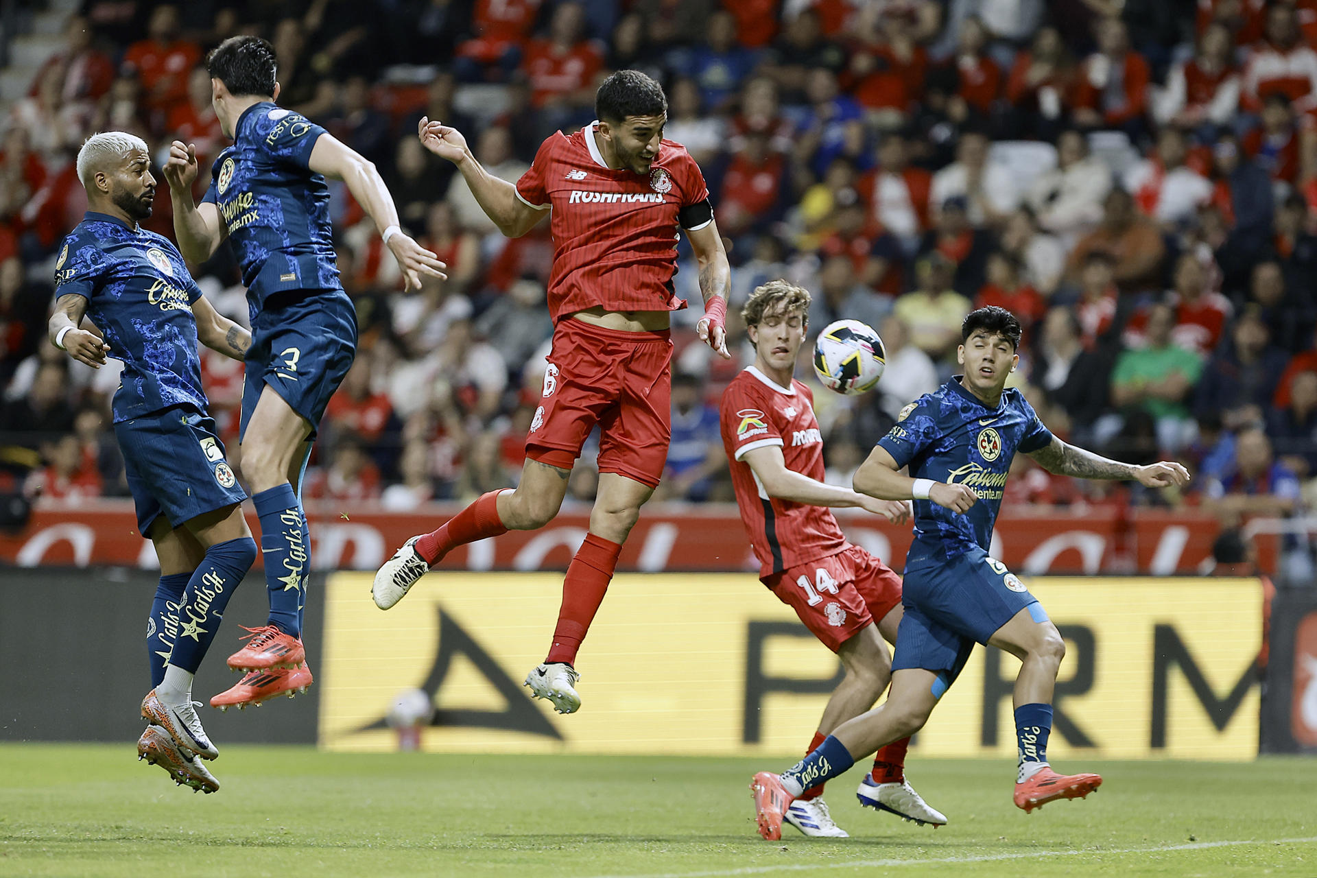 Andres Pereira (c) de Toluca disputa el balón con los jugadores de América Rodrigo Aguirre (i) e Israel Reyes (d) este sábado, en partido por la jornada 17 del torneo Apertura mexicano jugado en el estadio Nemesio Diez. EFE/Alex Cruz
