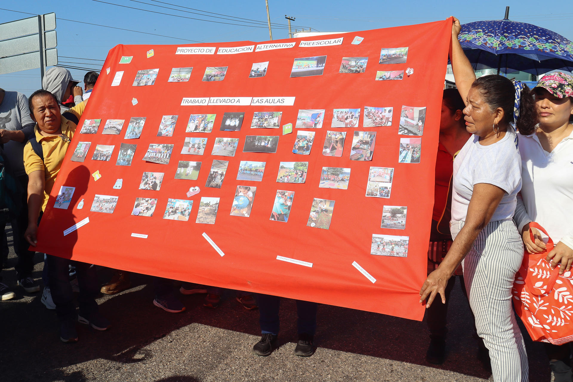 Dos personas pertenecientes a la Coordinadora Nacional de Trabajadores de la Educación (CNTE) sostienen una pancarta durante un bloqueo en las principales carreteras del municipio de Tapachula este martes, en Chiapas (México). EFE/ Juan Manuel Blanco
