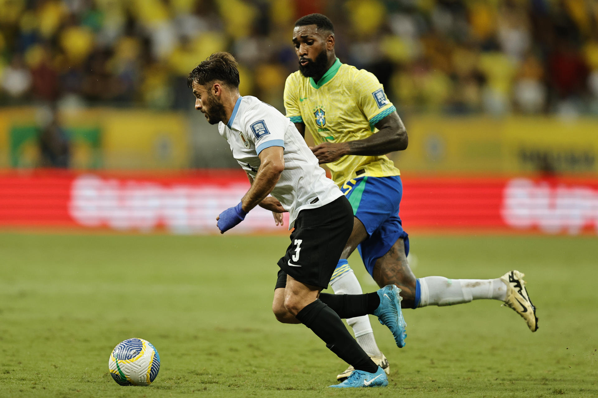 Gerson (d) de Brasil disputa el balón con Marcelo Saracchi de Uruguay en un partido de las eliminatorias sudamericanas para el Mundial de 2026. EFE/ Isaac Fontana
