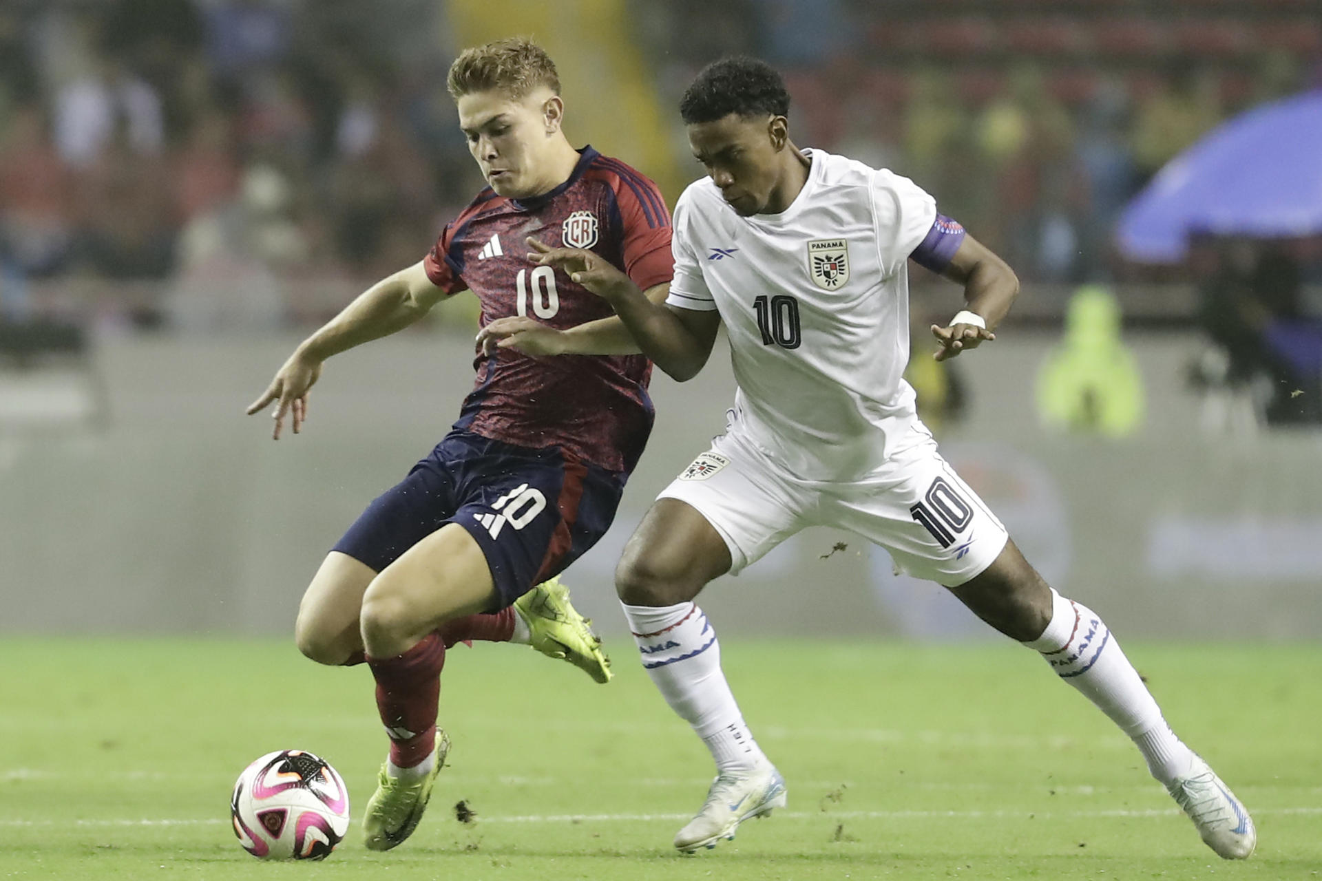 Brandon Aguilera (i) de Costa Rica disputa un balón con Édgar Bárcenas de Panamá en un partido de la Copa Centroamericana. EFE/ Jeffrey Arguedas
