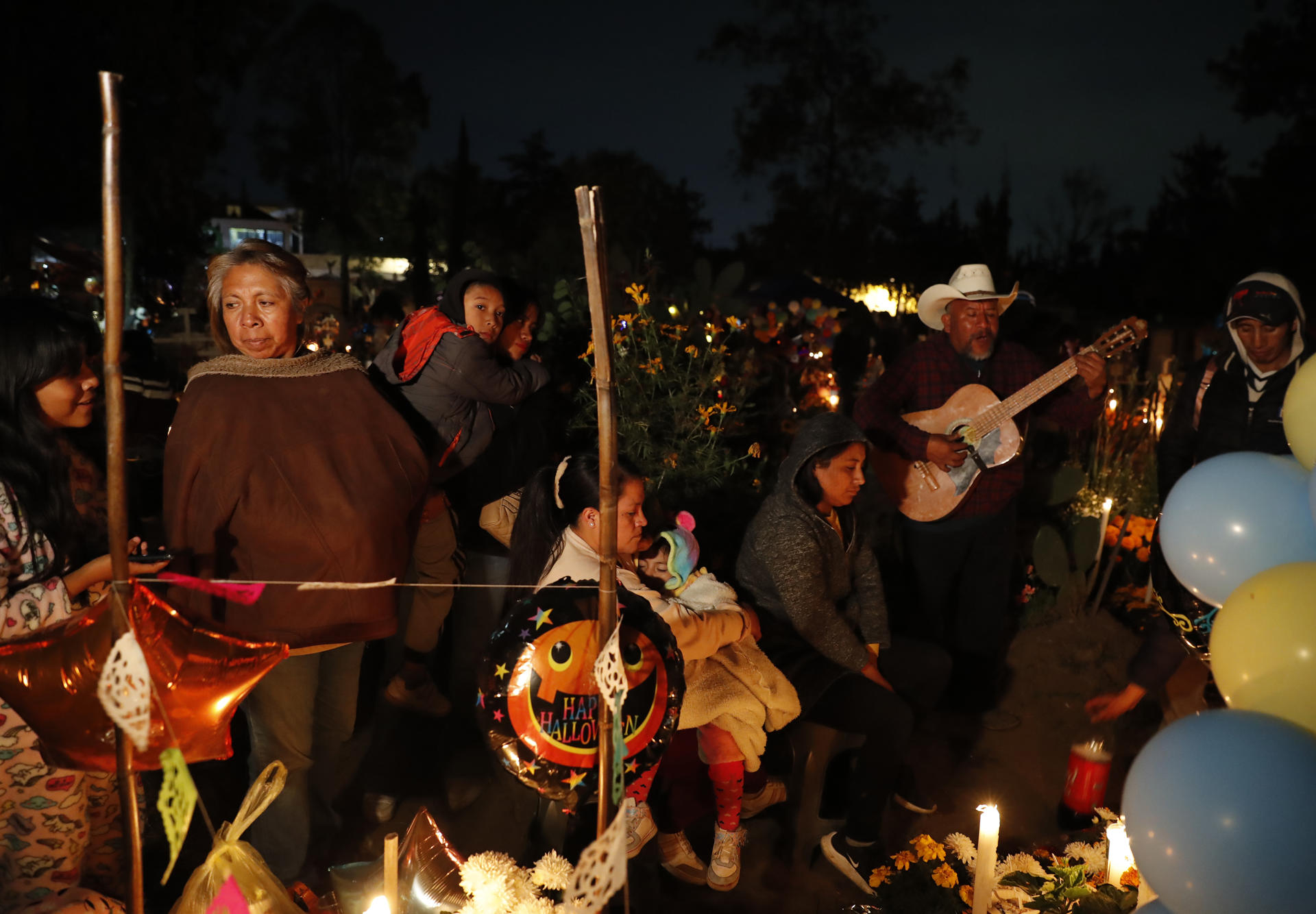 Familiares y amigos visitan a sus fieles difuntos la madrugada de este viernes en el panteón comunal San Gregorio Atlapulco, en la Ciudad de México (México). EFE/Mario Guzmán
