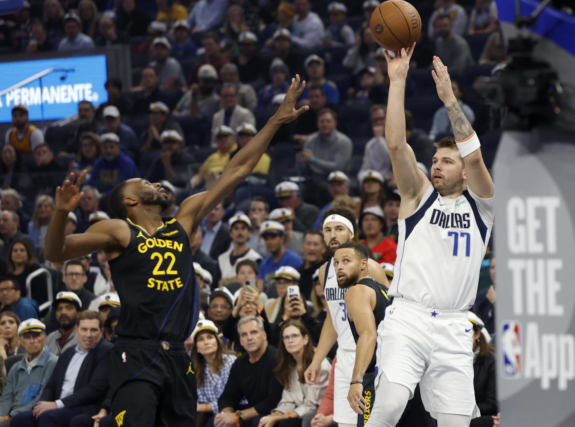 El escolta de los Dallas Mavericks Luka Doncic (D) lanza ante la oposición del alero de los Golden State Warriors, Andrew Wiggins (I). EFE/EPA/JOHN G. MABANGLO SHUTTERSTOCK OUT
