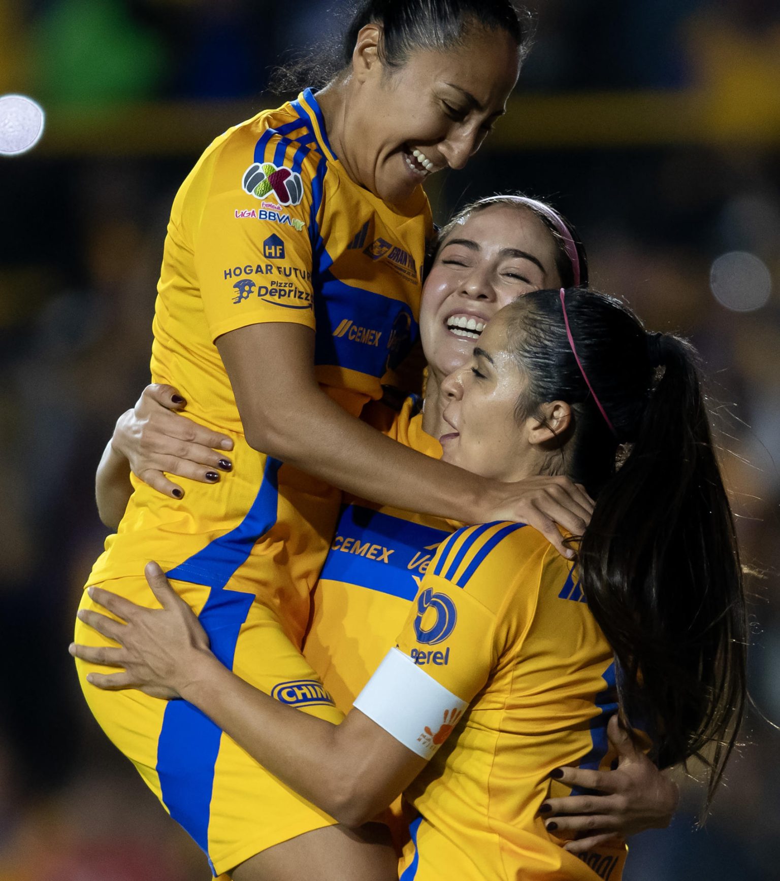 Greta Espinoza (c), Sandra Mayor (i) y Cristina Ferral celebran este viernes la victoria de Tigres sobre Monterrey en el partido de ida de la final del Torneo Apertura femenino en México. EFE/ Miguel Sierra