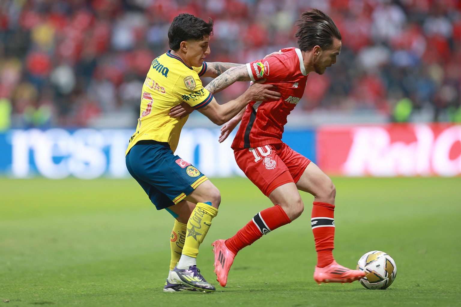 Jesús Angulo (d) de Toluca disputa un balón con Alejandro Zendejas de América durante un partido de vuelta de los cuartos de final del torneo Apertura 2024 de la Liga MX. EFE/Alex Cruz