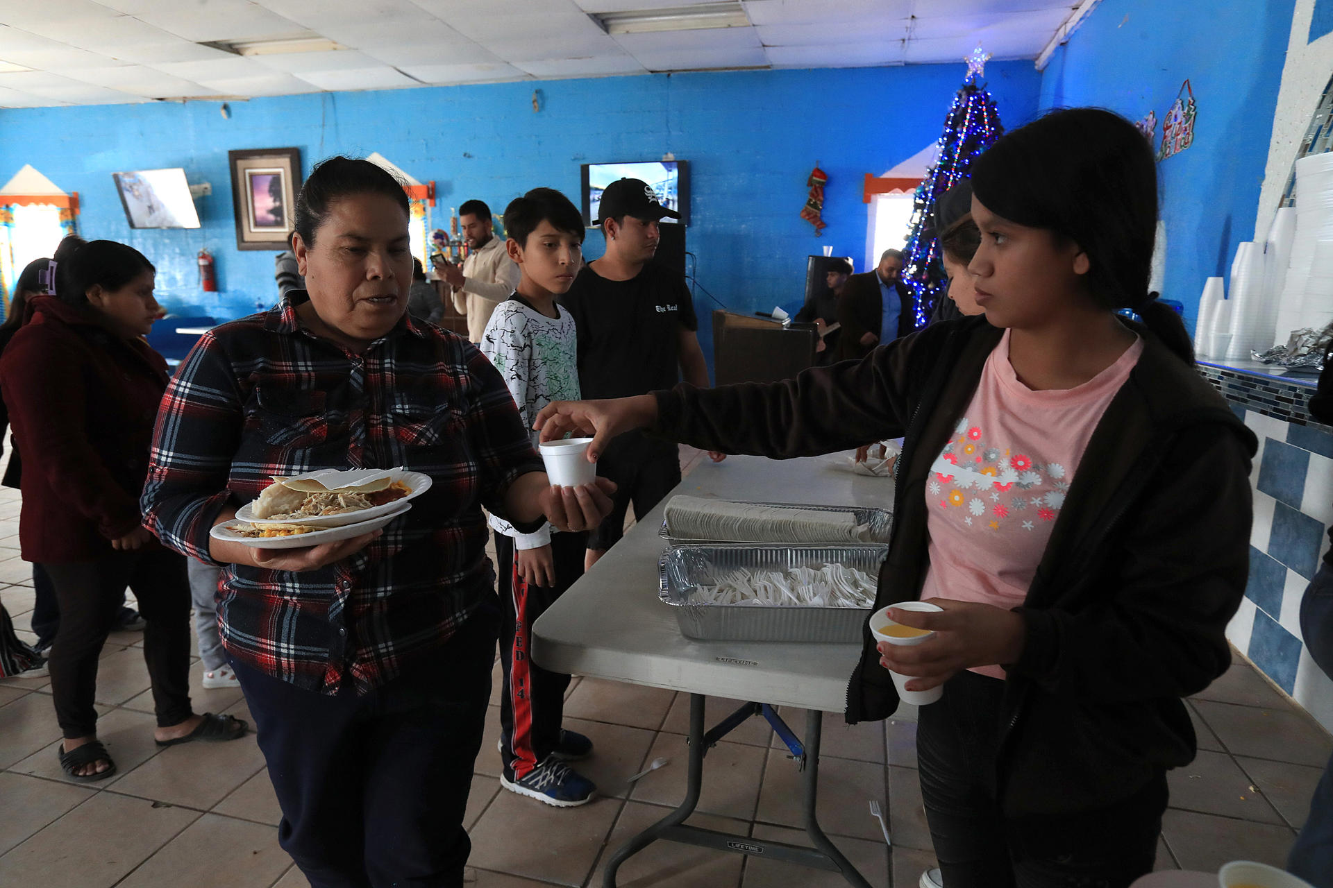 Migrantes reciben alimentos en el albergue 'Pan de Vida' con motivo del 'Día de Acción de Gracias', este jueves en Ciudad Juárez, estado de Chihuahua (México). EFE/ Luis Torres
