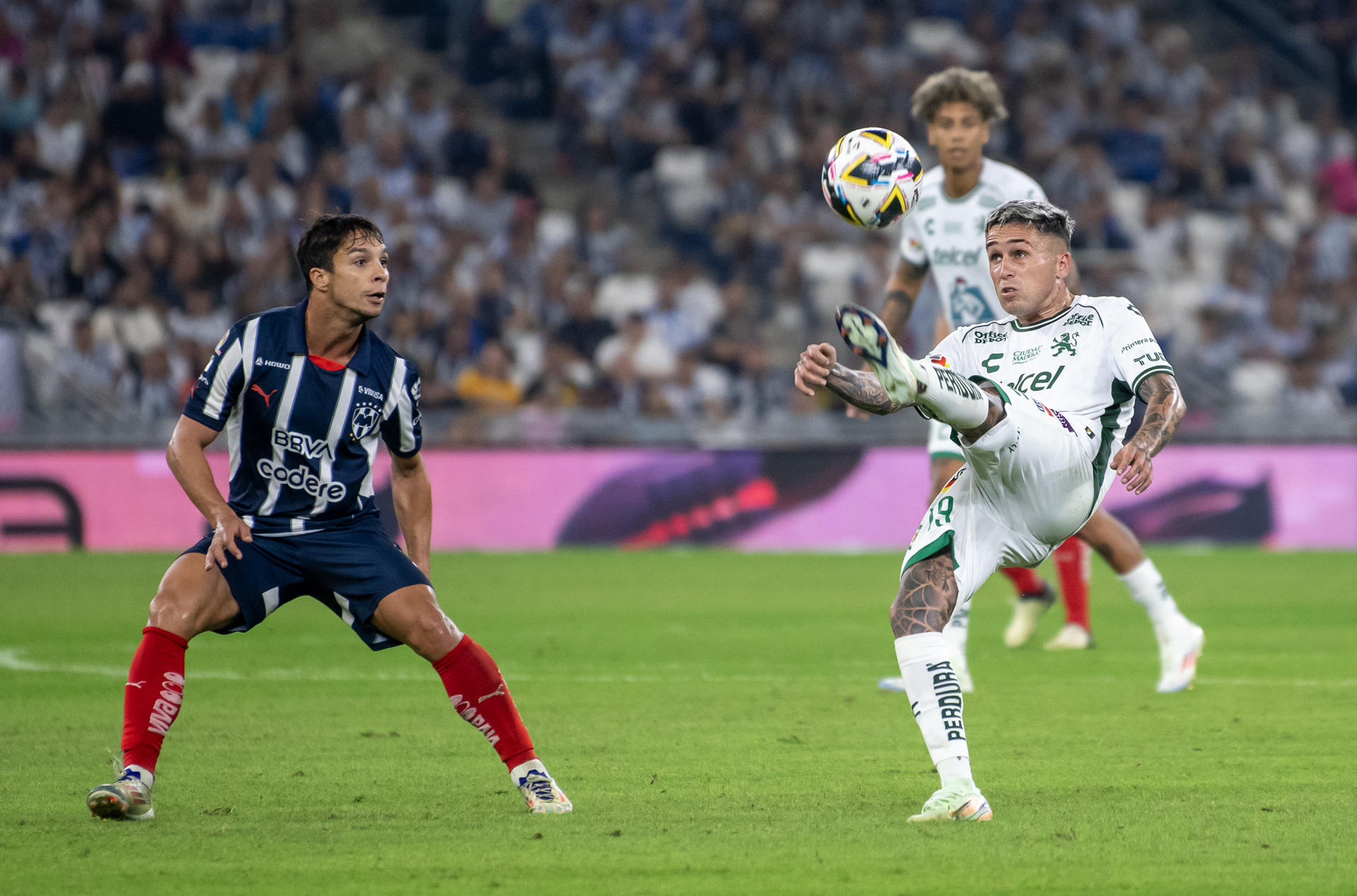 Oliver Torres (i) de Monterrey disputa el balón con Jordy Alcivar de León este domingo en un partido de la última jornada de la fase regular del Torneo Apertura jugado en el estadio BBVA. EFE/Miguel Sierra.
