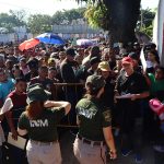 Personal del Instituto Nacional de Migración (INM) hablan con migrantes que esperan resolver su situación migratoria, el 31 de octubre de 2024, en la ciudad de Tapachula (México). EFE/Juan Manuel Blanco