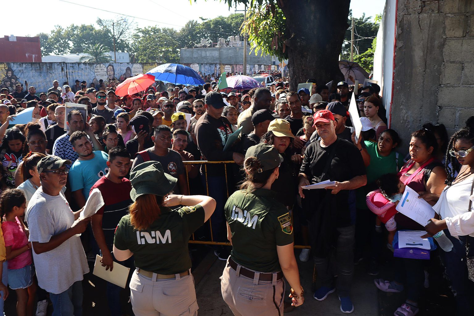 Personal del Instituto Nacional de Migración (INM) hablan con migrantes que esperan resolver su situación migratoria, el 31 de octubre de 2024, en la ciudad de Tapachula (México). EFE/Juan Manuel Blanco