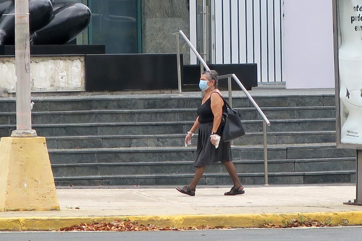 Una mujer que viste una máscara camina en una calle en San Juan, Puerto Rico. Imagen de archivo. EFE/Jorge Muñiz