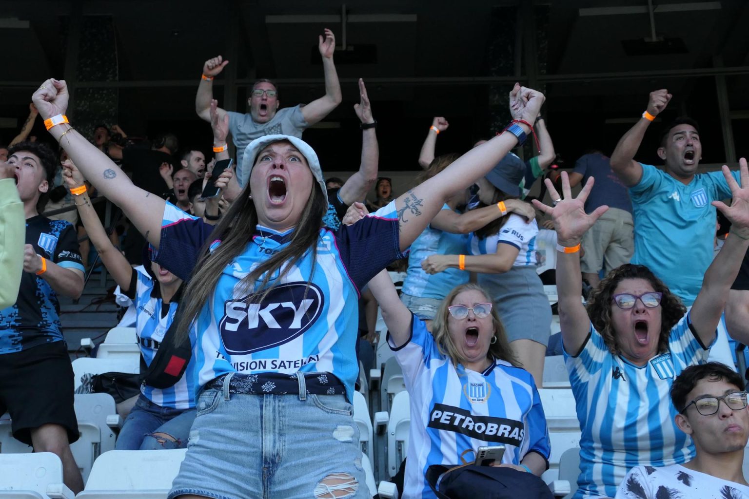 Reunidos este sábado en las tribunas del estadio Presidente Perón, en Avellaneda, para seguir a través de pantallas gigantes de televisión la final de la Copa Sudamericana, seguidores del club argentino Racing celebran uno de los tres goles infligidos a Cruzeiro en Asunción. EFE/ Enrique Garcia Medina