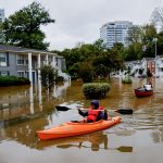 Fotografía de archivo fechada el 27 de septiembre de 2024 de Candice Ocvil (i) y Jibri Tolen (d), residentes de Peachtree Park, remando a través de las aguas de la inundación después de que la tormenta tropical Helene atravesó Atlanta, Georgia (EE.UU.). EFE/EPA/ERIK S. LESSER/ARCHIVO