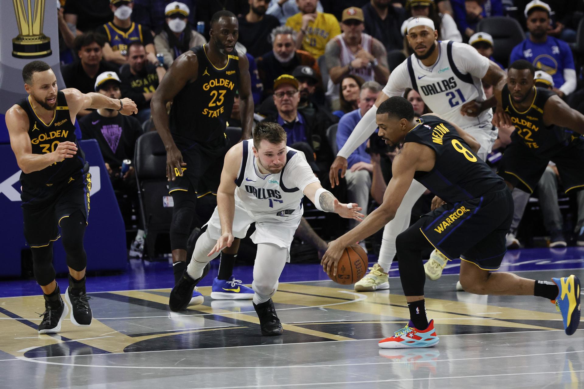 El escolta de los Golden State Warriors De'Anthony Melton (D) roba el balón al escolta de los Dallas Mavericks Luka Doncic (C), durante los últimos minutos del partido del torneo Emirates NBA Cup. EFE/EPA/JOHN G. MABANGLO SHUTTERSTOCK FUERA
