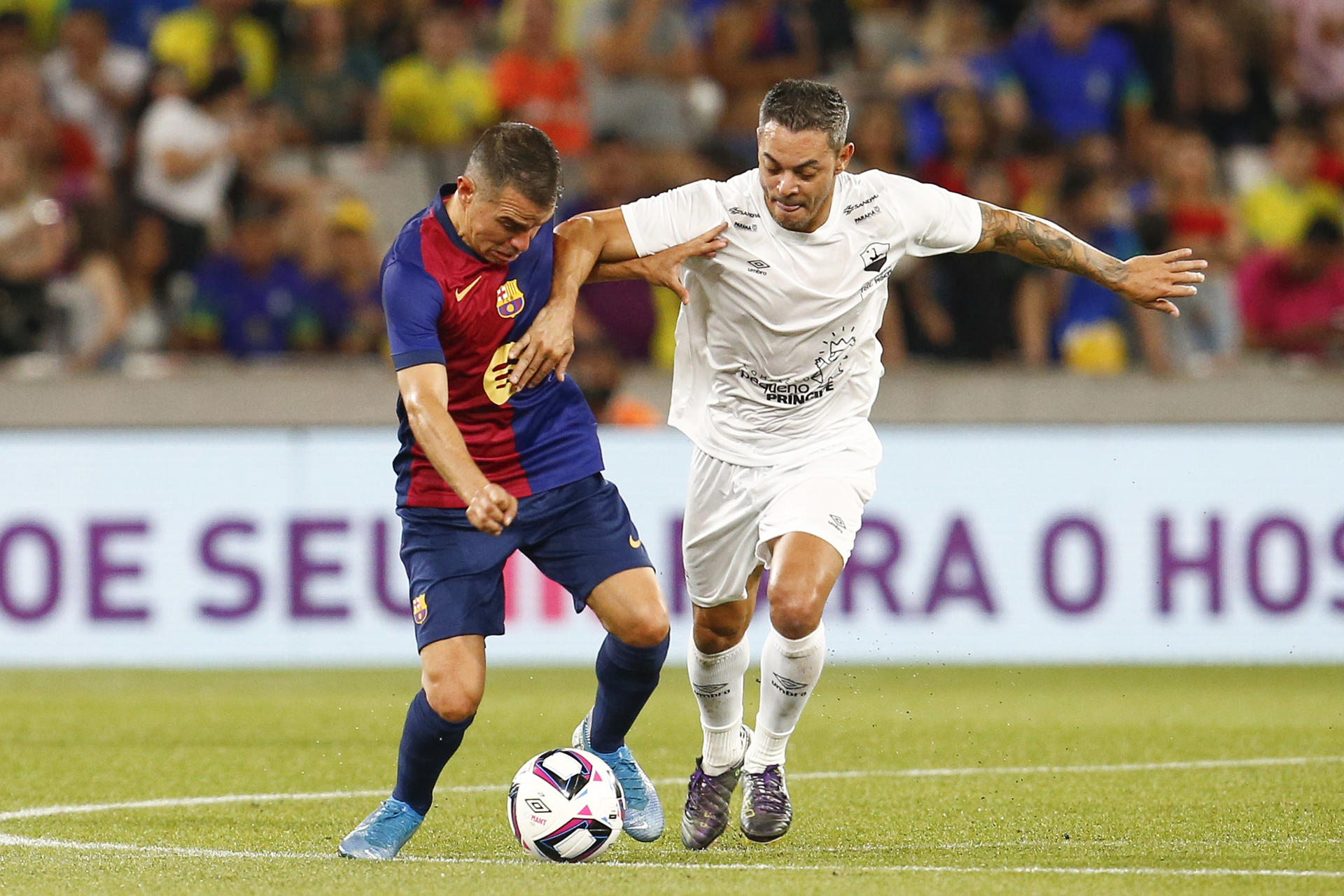 Javier Saviola (i) de Barcelona disputa un balón con Josué en un partido amistoso en el estadio Liga Arena entre Barcelona y Pelé Pequeño Príncipe en Curitiba (Brasil). EFE/ Hedeson Alves
