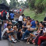 Migrantes descansan sobre una vía este lunes, en el municipio de Huehuetán (México). EFE/ Juan Manuel Blanco