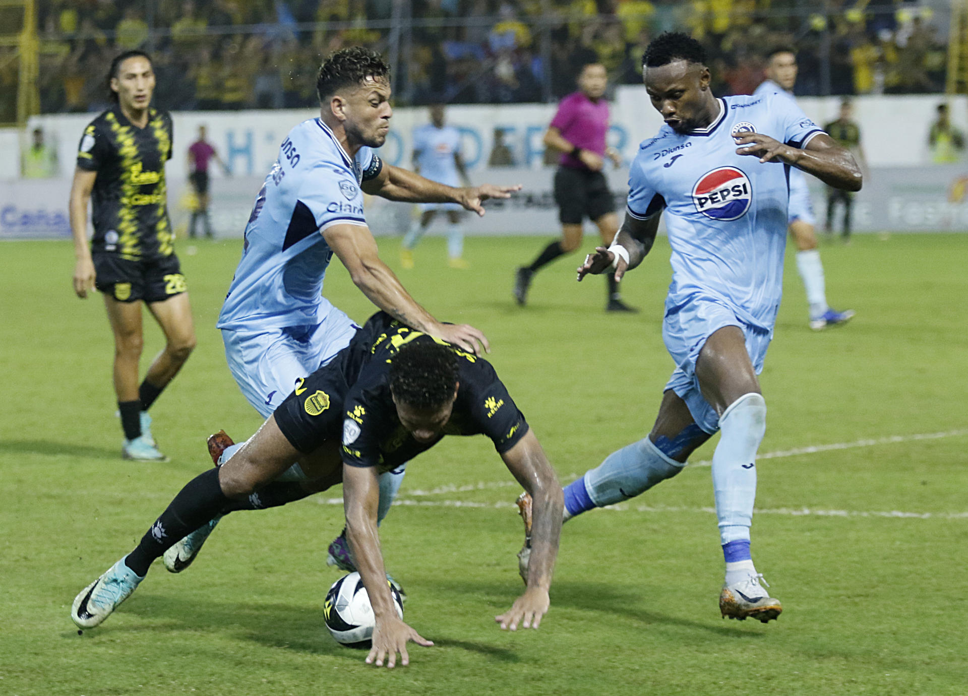 Marcelo Santos (i) y Ricky Zapata de Motagua disputan el balón con Jack Baptiste (c) de Real España, este jueves durante el partido de ida de las semifinales del torneo Apertura hondureñ. EFE/ José Valle
